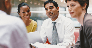 Two women and a man interviewing another man