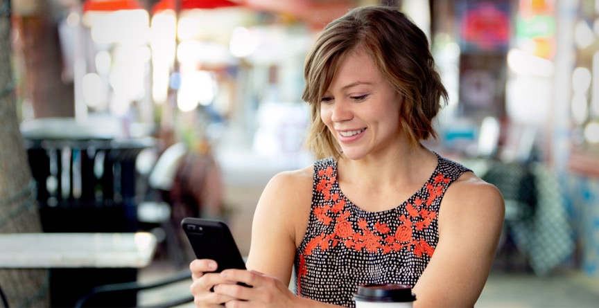 Lady smiles at phone.