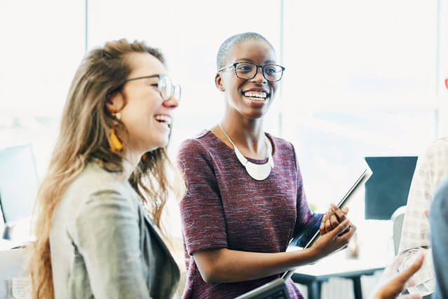 2 women talking and smiling.
