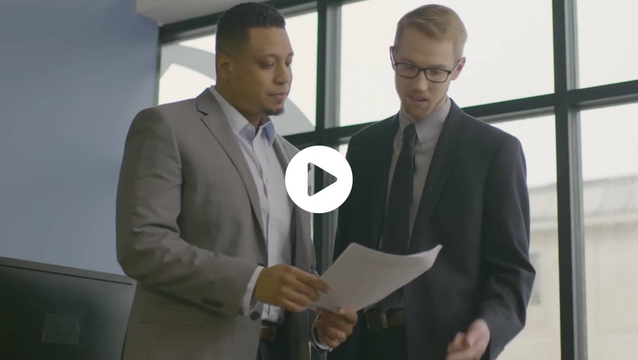 Two businessmen looking at a piece of paper.