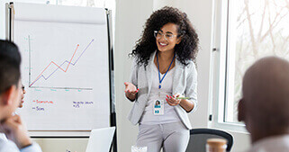 A woman presenting a graph in front a room