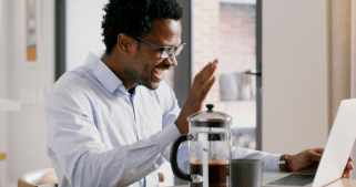 A man waving to a laptop