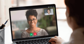 A man video chating with a woman on a laptop