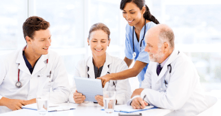 Four medical personals looking at a tablet