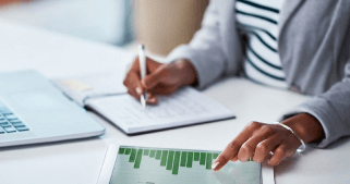 A woman writing and pointing at a graph